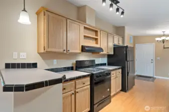 Gally Kitchen with serving or breakfast bar. Adjacent to dining room and a flex room. Walk-in pantry and laundry are adjacent the back door in this photo. Range and vent hood are brand new.