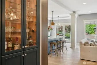 Thoughtfully designed kitchen area featuring a built-in wet bar with glass-front cabinetry, ideal for entertaining and everyday convenience. Positioned between the kitchen and living space, this feature enhances functionality while maintaining a seamless open-concept flow.