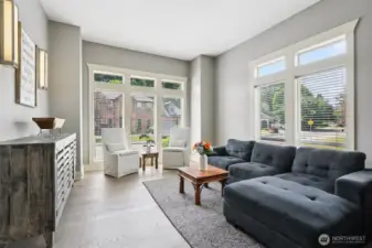 Inviting main-level living room featuring large windows, abundant natural light, and an open, comfortable layout. The space offers flexibility for seating and everyday living, with easy flow to adjacent dining and kitchen areas.