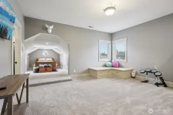 Expansive upstairs loft offering a versatile layout with plush carpeting, built-in seating, and abundant natural light. This flexible space functions well as a media room, play area, home office, or additional living space, with architectural interest and convenient access to nearby bedrooms.