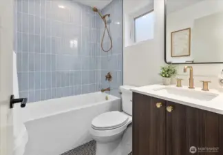 Full bathroom with custom tiling on first floor.
