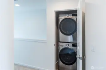 Stacking laundry in bedroom hallway