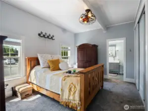 Main floor primary bedroom suite features 9 foot ceilings, double closets and a beautifully remodeled bathroom.