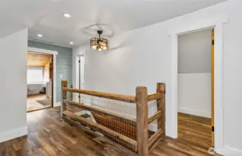 At the top of the stairs is the hallway between the primary bath & bedroom.  Love the creative wood staircase!