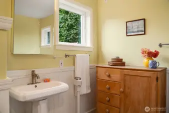 Second level bathroom with a deluxe soaking tub, separate shower and farmhouse detailing.