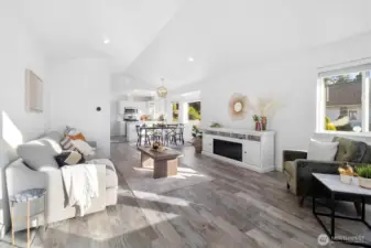 Bright, open living room featuring a cozy fireplace and large windows.