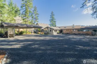 This property boosts a main home (on the right), a guest house (left, center) and a natatorium that connects the two that has a swim spa, hot tub, and infrared sauna.  Lots of room to park, including a 3 car carport.