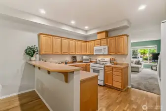 Kitchen opens to family room and features eating bar as well as lots of cabinets.