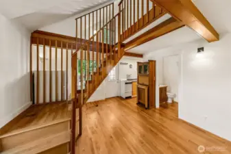Apartment #7 - On the second floor with a small deck area, apartment 7 features oak floors, small kitchen, full bathroom and repurposed storage hutch from an area houseboat with built in garbage container, chopping block, and storage cabinet with glass doors. Follow the timber frame stairs up to the spacious sleeping loft.