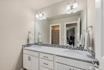 Full bathroom w/double vanity, quartz counter tops w/tile backsplash, tile floors & private toilet/shower space.