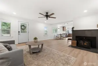New LVP flooring, recessed lighting, tiled fireplace, and beautiful window trim