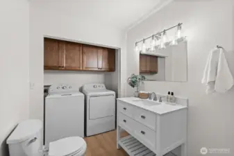 The 3/4 bath with a brand new washer and dryer set and cabinets above