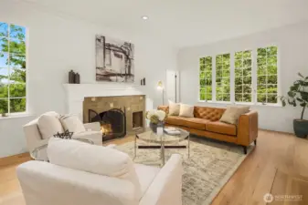 Spacious living room with a classic fireplace and abundant natural light