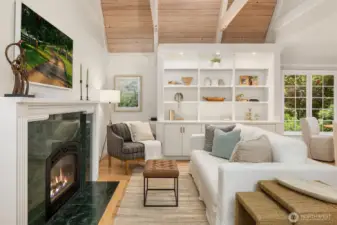Vaulted family room with fireplace, built-ins, and abundant natural light