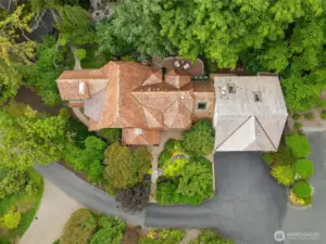 Aerial view showcases the Tudor architecture nestled among mature trees
