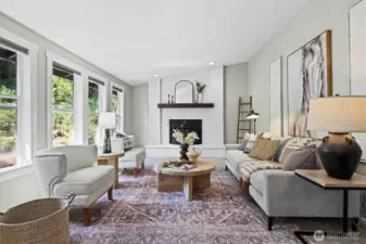 Natural light floods the living room, with its cozy fireplace