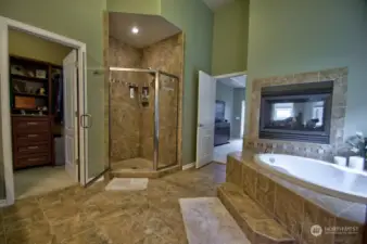 Heated Tile flooring and towel racks. Oversized shower and live in closet. view into the bedroom