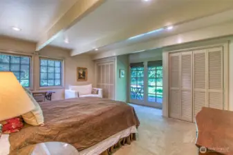 Main-level primary bedroom with en-suite bath and French doors opening to a small deck with serene pond views.