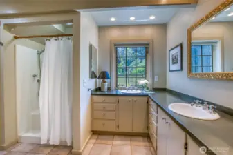 Spacious en-suite bath with a shower in the main-level primary bedroom.