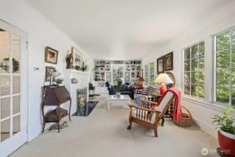French doors to the left open up to the perfect conversation room to gather around the warm fireplace.