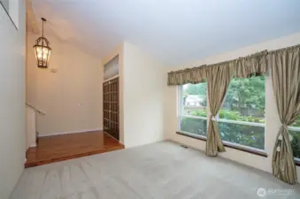 As you enter the home, you are greeted by the main-floor living area, featuring three large picture windows and newer carpeting.