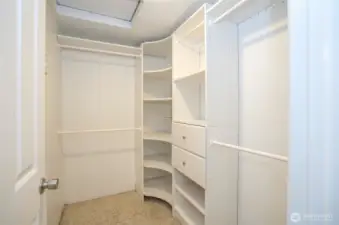 Primary suite walk-in closet, complete with built-in cubbies and drawers for organized storage.