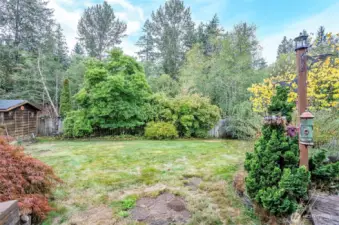 View of the backyard from the deck, with an outbuilding situated just to the left.