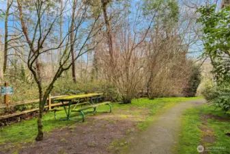 Nearby greenbelt trail with picnic seating offers a quiet place to pause, unwind, and enjoy the surrounding landscape.