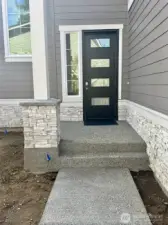 Covered entry porch, has 8' tall entry door with 4 glass panels