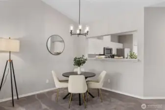 Bright living room with gas fireplace, ceiling fan and vaulted ceilings.
