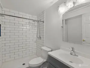 Remodeled bathroom features quartz counter & subway tile shower surround.