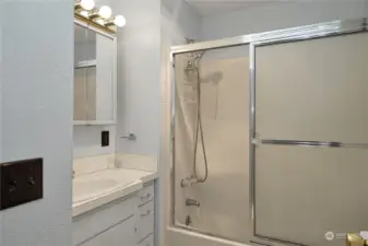 Full bathroom with old Hollywood overhead lighting.