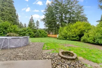 Another view of back yard showing pool and firepit.