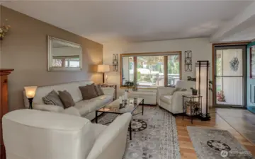 Living room with warm tones, bay window and wood fireplace
