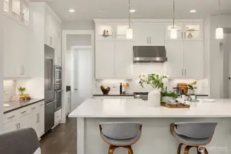 Beyond refrigerator is a work area and a spacious pantry behind the door