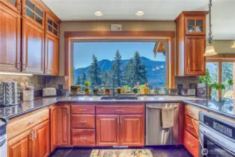 Perfect floorplan & utilization of view, this kitchen takes the cake! Stainless appliances, slate floors, granite counters, & polished wood cabinets.
