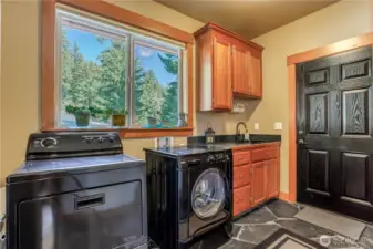 Laundry room entry off the side deck makes it easy to load groceries into the kitchen or clean up easily at the utility sink. View to the driveway side & plenty of storage.