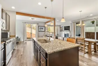 Open kitchen with oversized island flowing seamlessly into dining and living areas.