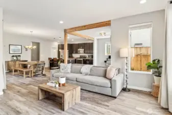 Open living area with fireplace and direct connection to kitchen and dining spaces.