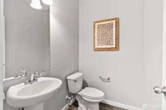 Main level half bath with clean finishes and convenient access for guests.