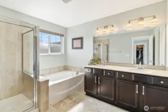 Primary bathroom with double vanity, soaking tub, and separate shower.
