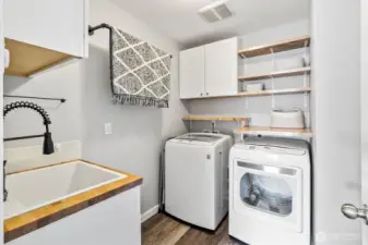 Laundry room with built-in shelving and utility sink.