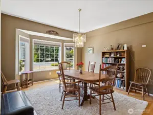 Formal dining area with big windows.