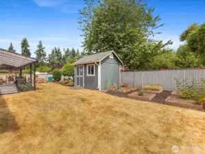 Expansive outdoor spaces with fully fenced Yard, Garden, Raised Beds & Outbuilding/Shed.