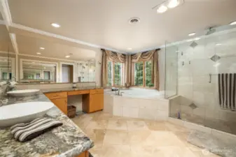 Primary bathroom with double sinks, large jetted tub and large walk in shower with travertine flooring.