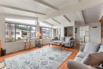 The living space features vaulted ceilings and abundant natural light from large windows