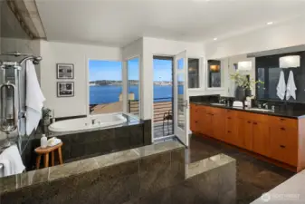 A soaking tub with amazing views is in the center just off the private deck and dual vanity cabinets.