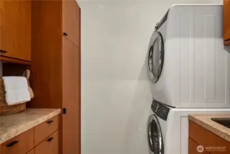 Just off the huge walk-in closet is this full size laundry room with a sink (to the right) and more built-ins with granite counters.