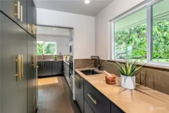 Floating sintered stone counters crafted by Neolith with solid maple soft-close cabinetry