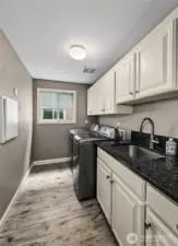 Laundry room off the kitchen is a nice touch in a condo.  Offers side by side space, laundry sink and many cabinets for storage.